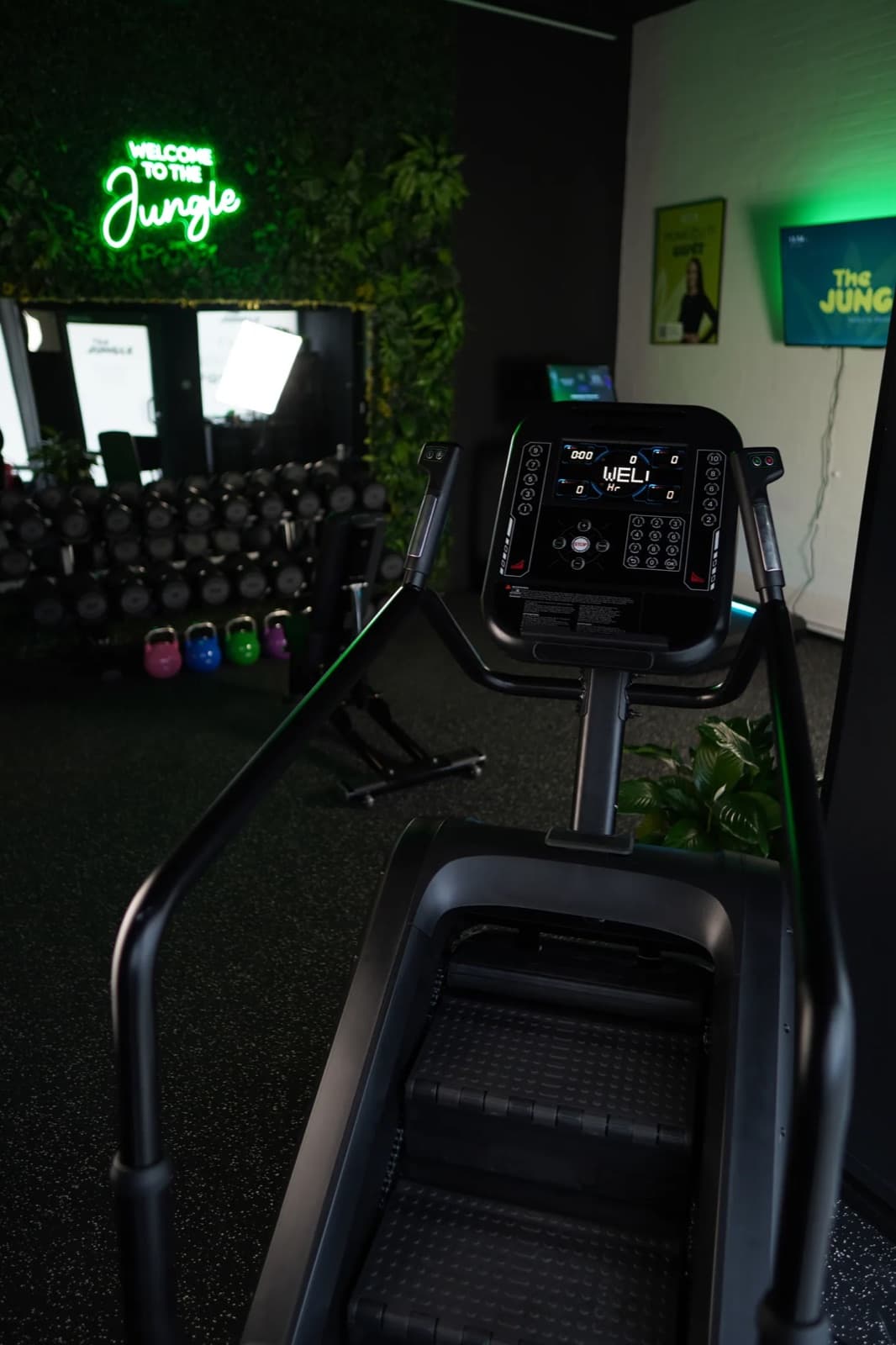 Fitness schody před svítícím neonovým nápisem v posilovně The Jungle